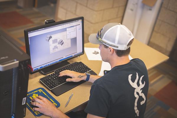 A manufacturing student creating a 3D model at a computer