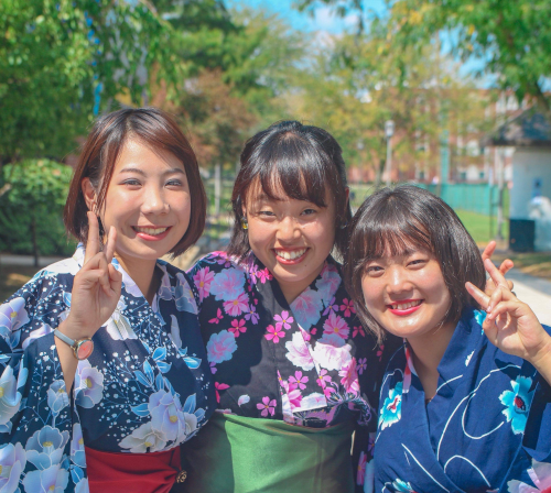 Two asian women give the V sign for 澳门足球博彩官方网址 when they visited for graduation