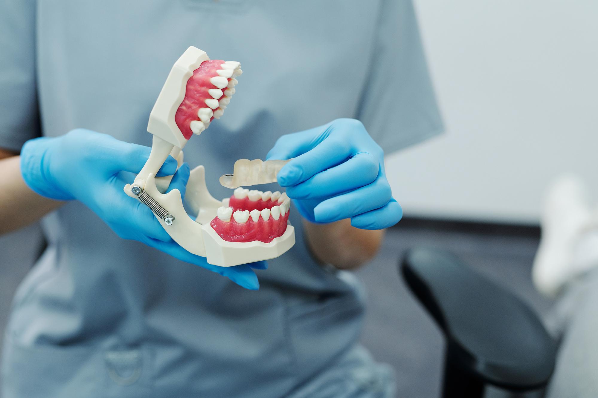 Dentist showing patient a pair of dentures.