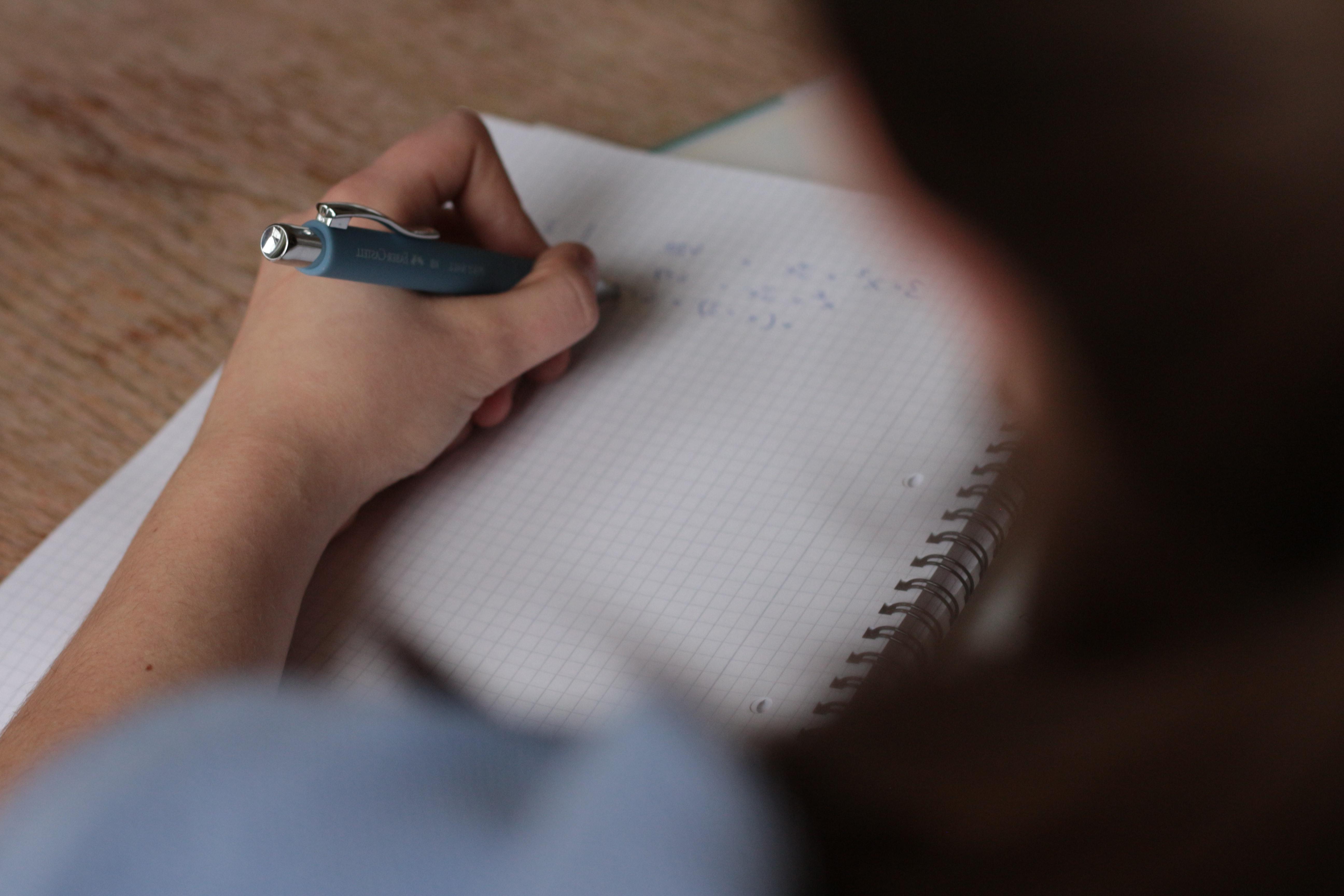 一个学生用笔在方格纸上书写