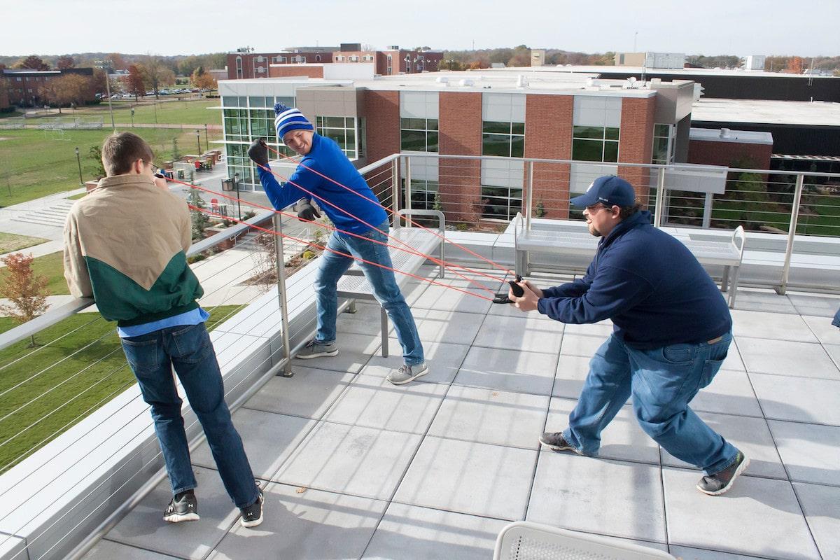 文森斯大学的学生用弹弓从厄普代克大厅的屋顶上发射水果