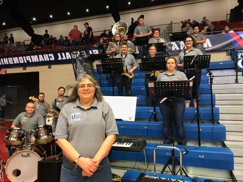 Sharon Jackson and the pep band posing for a photo in the gym