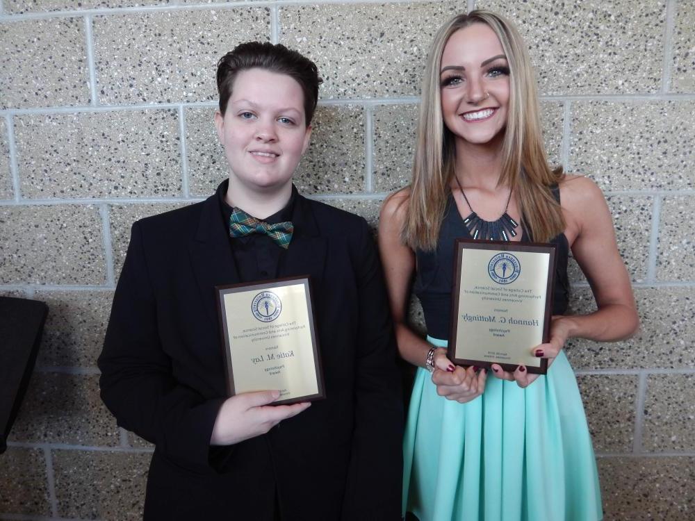 Two students holding psychology awards