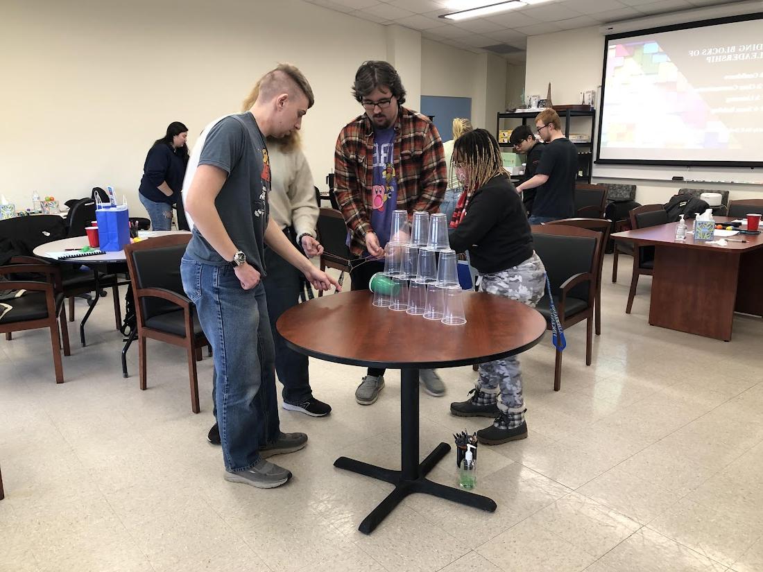 Students working together to stack cups