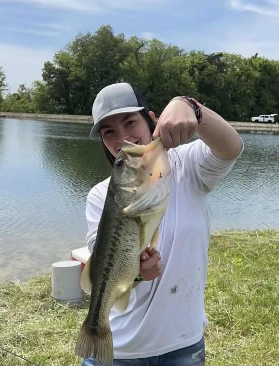 Student holds up a bass fish