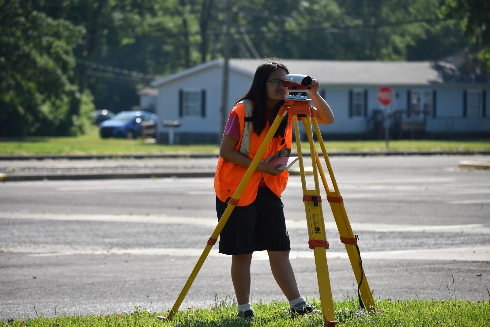 A female student looking into a surveying camera